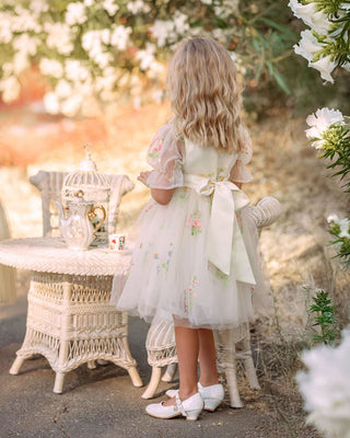 Girl in floral embroidered tulle dress from Faeella twirling in garden, perfect for keepsake photoshoots and outdoor party. Most comfortable and lightweight party dress for toddlers and girls