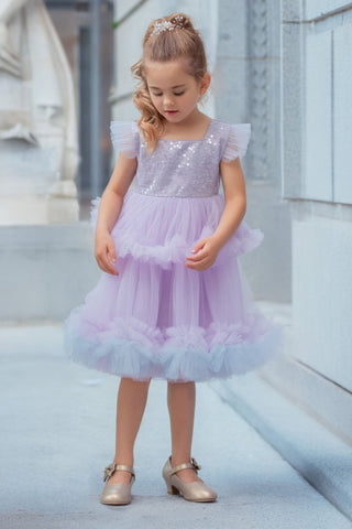 Girl wearing lavender sequin tulle dress holding white flowers. Perfect Faeella dress for itch free, comfortable flower girl moments and weddings.