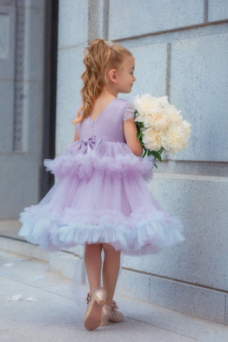 Girl wearing lavender sequin tulle dress holding white flowers. Perfect Faeella dress for itch free, comfortable flower girl moments and weddings.