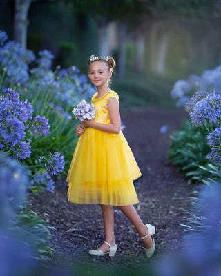 Girl in yellow floral embroidered tulle dress holding flowers for Faeella, perfect for spring photoshoot, birthday, party and everyday play