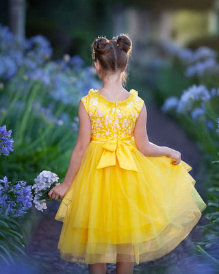 Girl in yellow floral embroidered tulle dress holding flowers for Faeella, perfect for spring photoshoot, birthday, party and everyday play