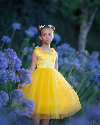 Girl in yellow floral embroidered tulle dress holding flowers for Faeella, perfect for spring photoshoot, birthday, party and everyday play