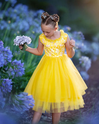 Girl in yellow floral embroidered tulle dress holding flowers for Faeella, perfect for spring photoshoot, birthday, party and everyday play