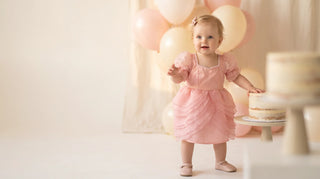 Blush pink pleated ruffle Faeella first birthday dress with soft balloons — small batch occasion dress